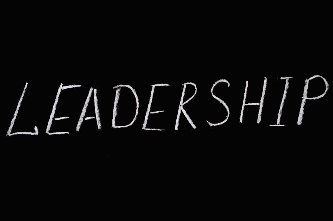 Chalk text spelling 'Leadership' on a blackboard, symbolizing guidance and authority.